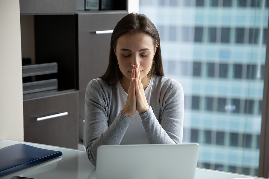 mujer frente al ordenador rezando sobre lo que lee